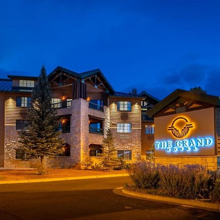 فندق ذا جراند آت جراند كانيون توسايان المظهر الخارجي الصورة The image shows a building featuring a sign that reads "The Grand." The structure appears to be a hotel or lodge, characterized by a combination of stone and wooden features. It is illuminated with warm lighting, which creates an inviting atmosphere.