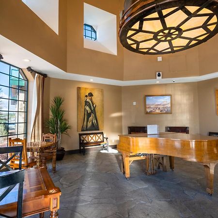 فندق ذا جراند آت جراند كانيون توسايان المظهر الخارجي الصورة The photo depicts a stylish interior space, likely a living room or lounge area. Key features include:

- A grand piano made of polished wood, centrally located.
- High ceilings with a large, decorative light fixture that resembles a wheel.
- Large w