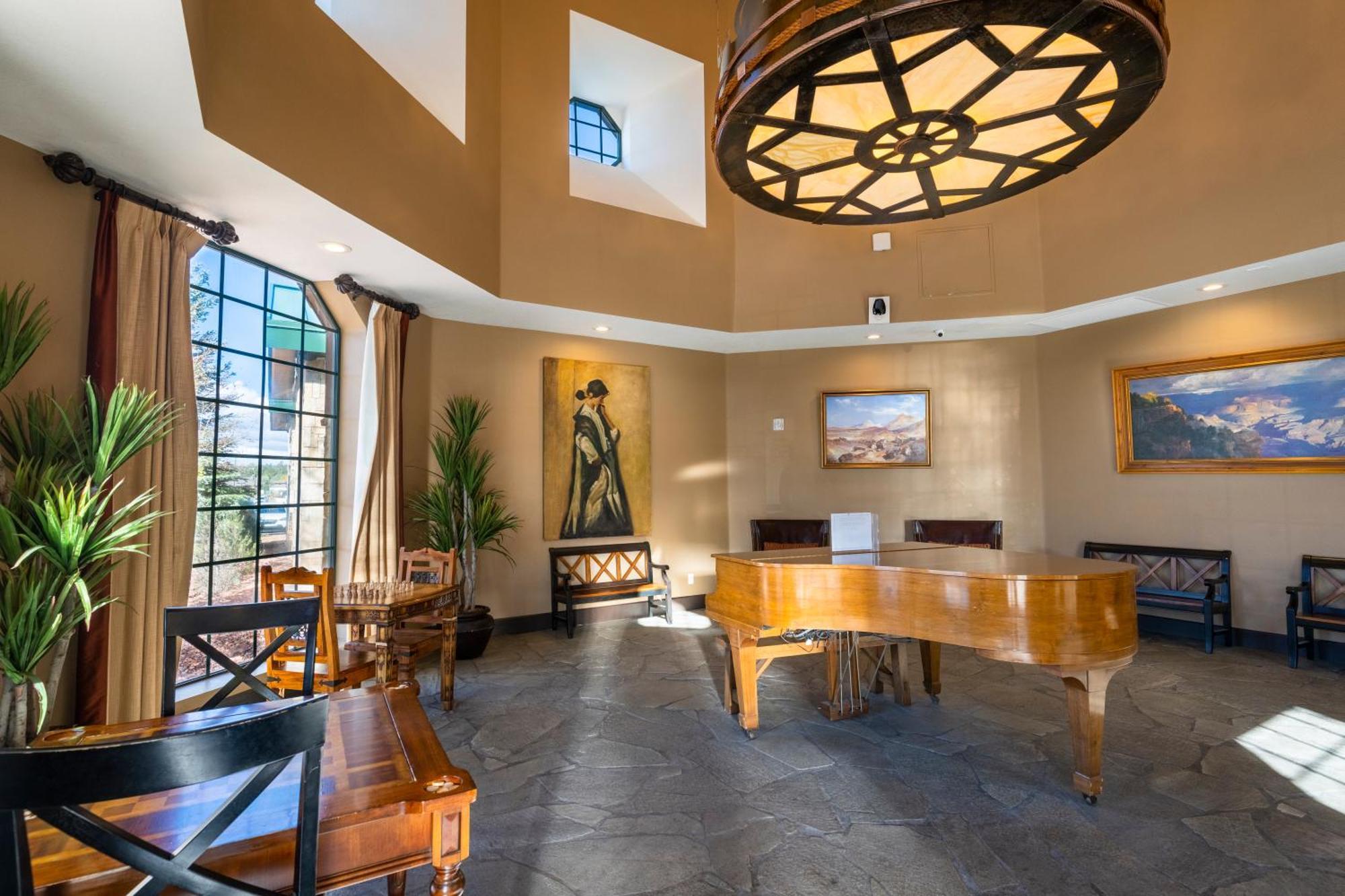 فندق ذا جراند آت جراند كانيون توسايان المظهر الخارجي الصورة The photo depicts a stylish interior space, likely a living room or lounge area. Key features include:

- A grand piano made of polished wood, centrally located.
- High ceilings with a large, decorative light fixture that resembles a wheel.
- Large w